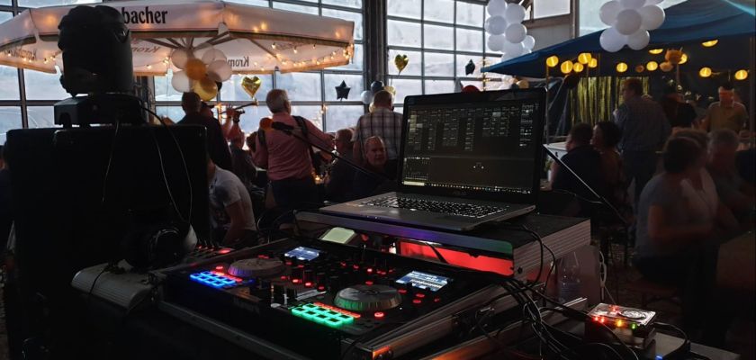 Aus der Perspektive des DJs: Hoffest in Liebenscheid mit sichtbarem Laptop, DJ-Pult und Live-Band auf der Bühne.