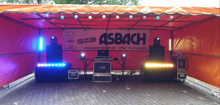 Orangefarbenes Zelt mit aufgebauter PA-Anlage, Moving Heads und LED-Bars.