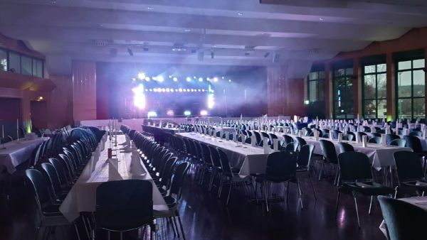 Westerwald Veranstaltungshalle mit beeindruckender Bühne, Licht- und Nebel-Show, professioneller Soundanlage und Tischen im Vordergrund