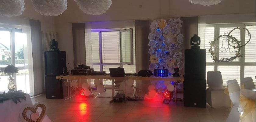 In der Mehrzweckhalle Marienrachdorf: Hochzeit mit aufgebauter PA-Anlage und rotem Licht, beleuchtet von LED-Scheinwerfern.